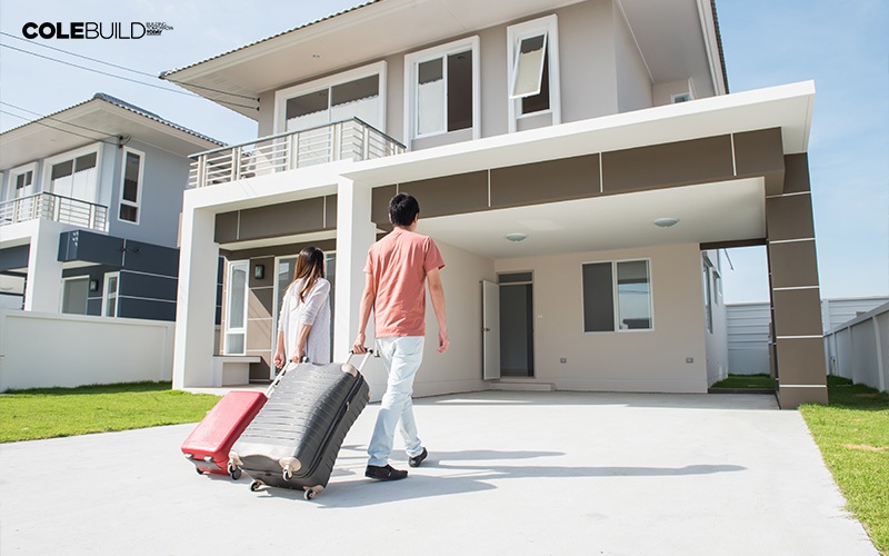 a couple with luggages going inside a landed home