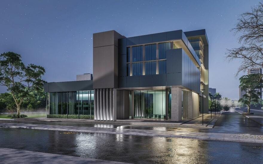 A contemporary building at night, illuminated by interior lights and streetlamps