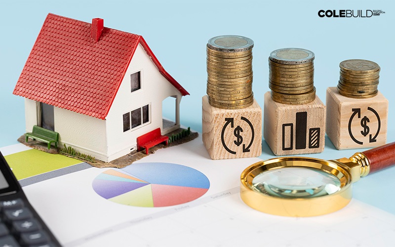 House model with coins and magnifying glass